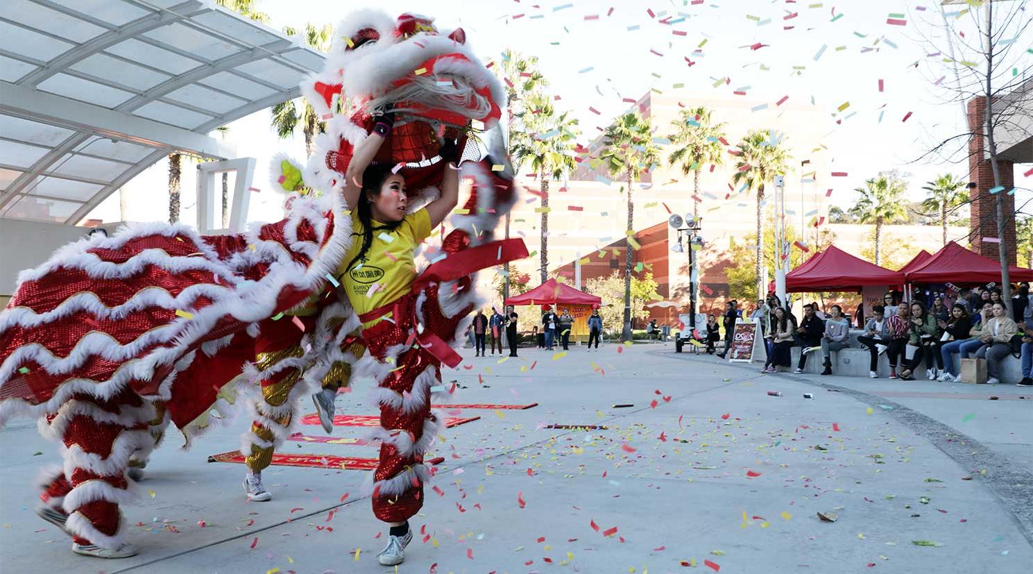 一个亚洲女学生穿着狮子服装跳舞